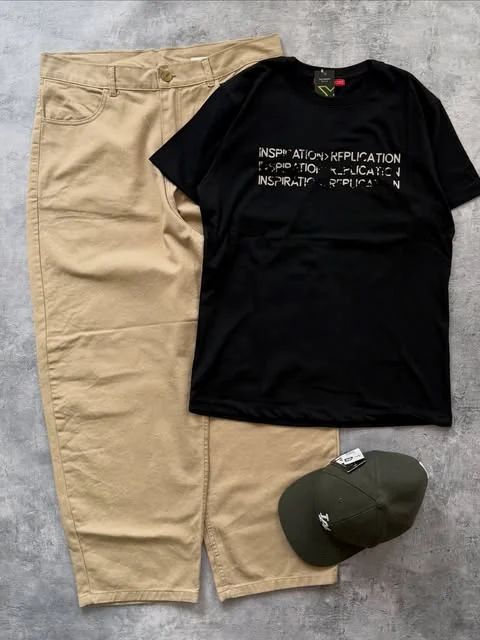 Pantalón chino beige con remera negra y gorra verde